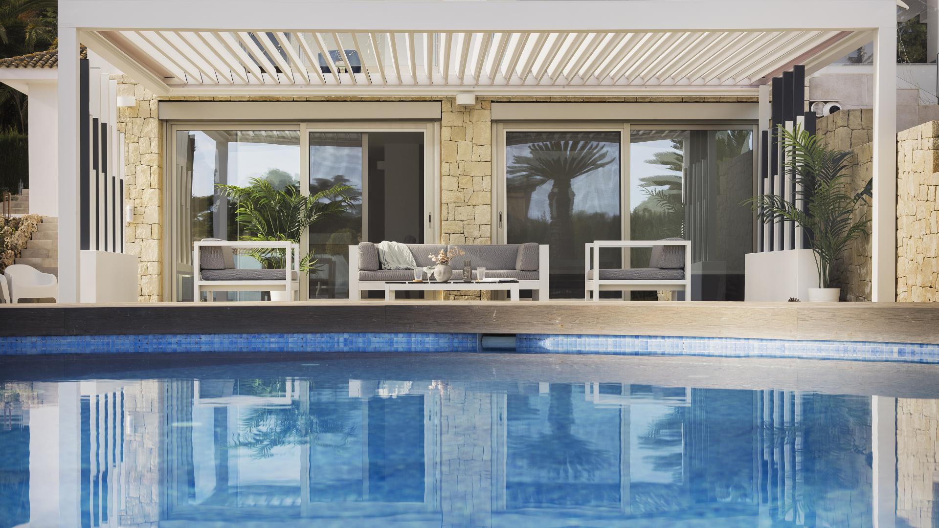 Pérgola bioclimática en vivienda junto a piscina