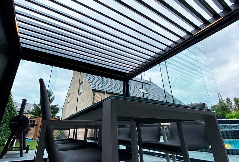 Vista interior de Pérgola modelo Altea acristalada con vistas a la piscina y al jardín