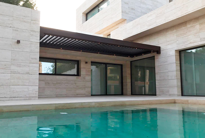 Bioclimatic wall pergola attached to 3 walls covering the access from the house to the terrace and pool
