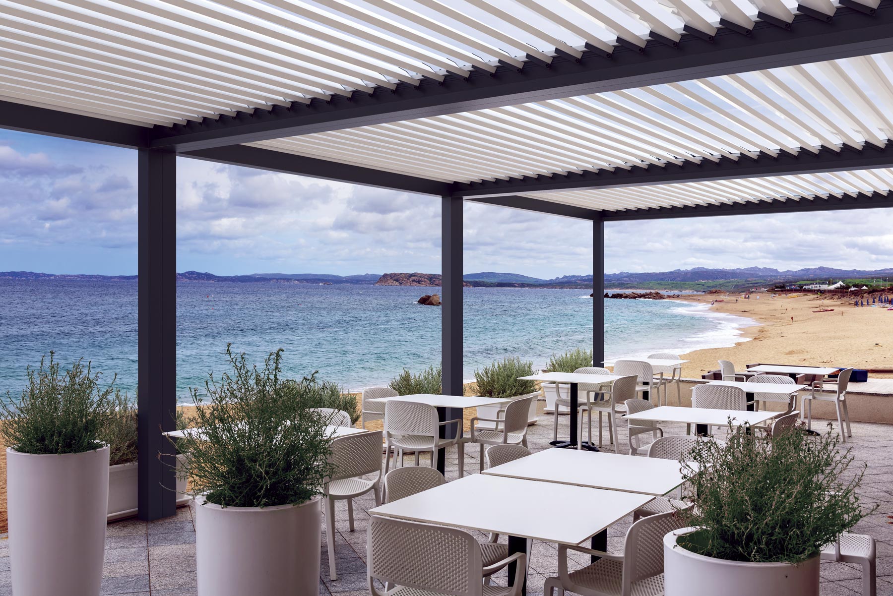 Terraza de restaurante que da al mar cubierta por una pérgola Bioclimática de tres módulos