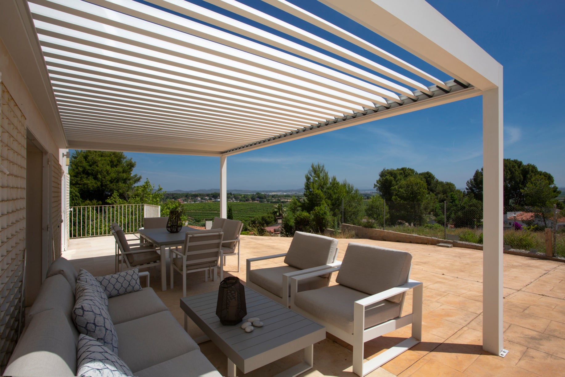 Pérgola bioclimática adosada a la vivienda con vista a paisaje en el campo