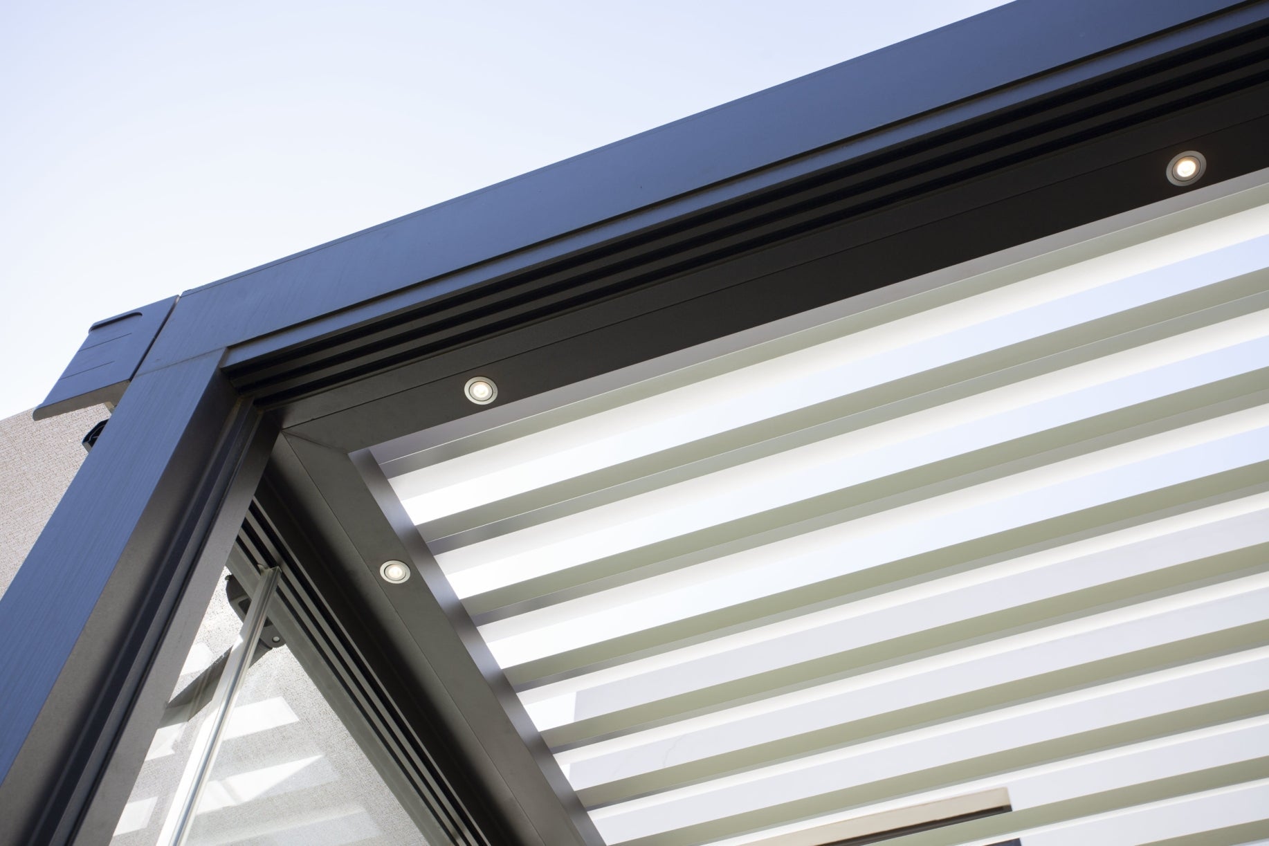 Bioclimatic pergola seen from below with integrated LED spotlights and open slats
